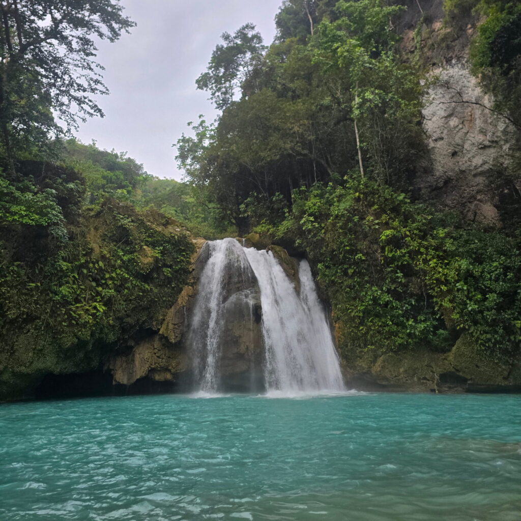 Beautiful Kawasan Falls in Badian, Cebu Kawasan Falls with crystal-clear turquoise water surrounded by lush green trees in Badian, Cebu, Philippines.