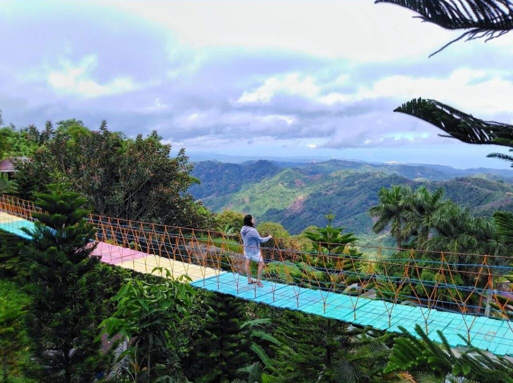 Colorful hanging bridge overlooking Cebu’s green mountains at JVR Island in the Sky.