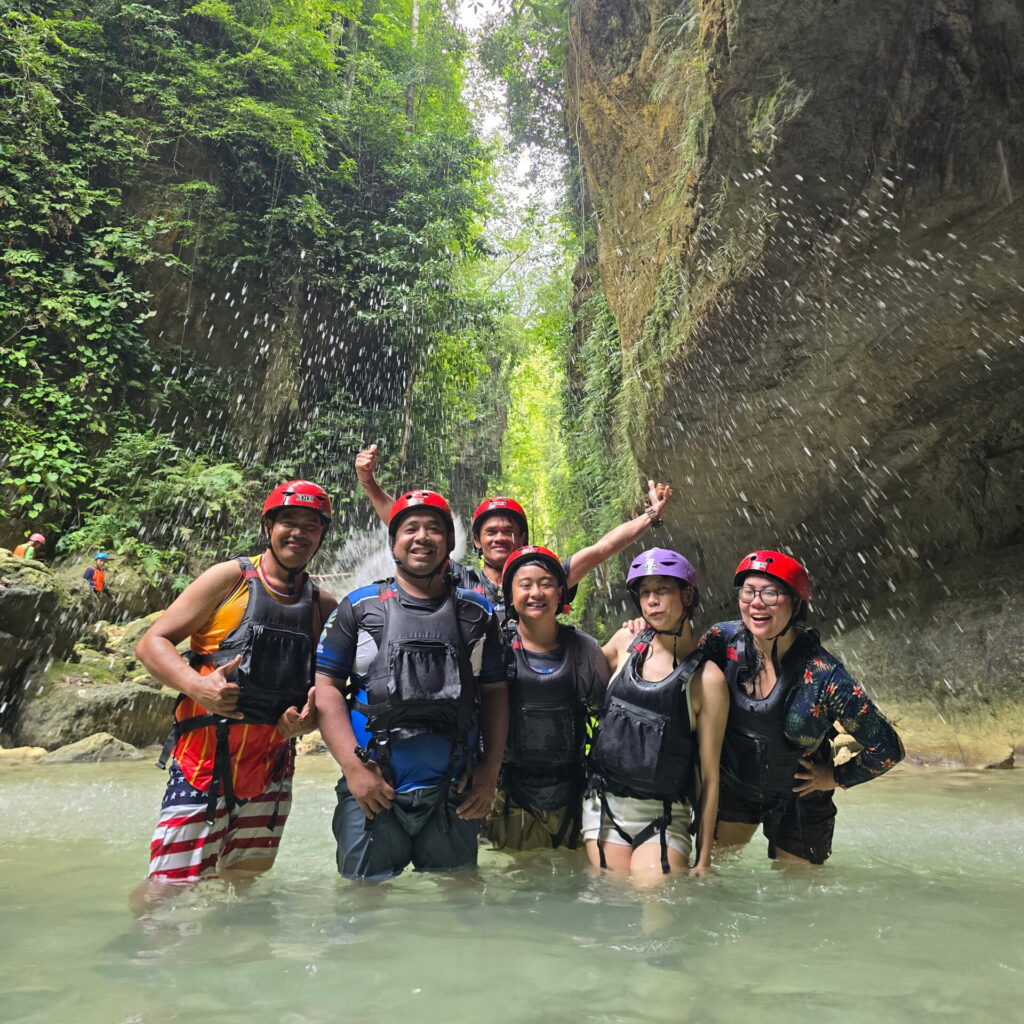 Local Tourists Enjoying Kawasan Canyoneering in Badian, Cebu A group of local tourists wearing helmets and life vests enjoying the Kawasan Canyoneering adventure in Badian, Cebu.