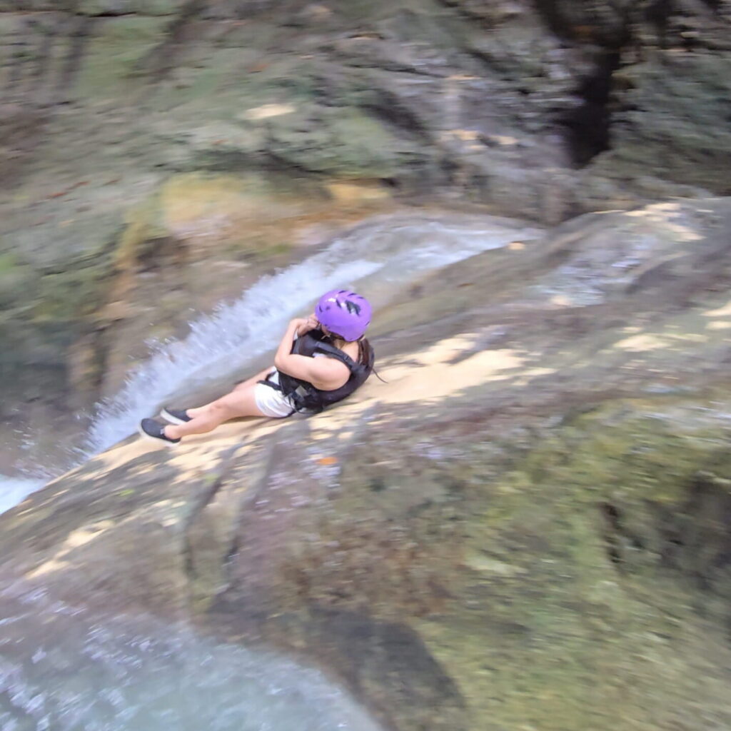 Natural Rock Slide at Kawasan Canyoneering in Badian, Cebu Natural rock slide surrounded by limestone cliffs during the Kawasan Canyoneering adventure in Badian, Cebu.