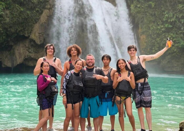 A group of tourists posing at Kawasan Falls after completing the canyoneering adventure in Badian, Cebu.