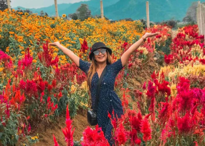 Visitor posing among colorful flowers at Sirao Flower Garden