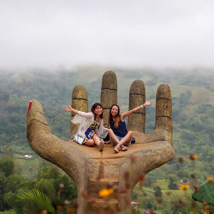 Giant Hand at Sirao Garden in Cebu Two visitors posing on the giant hand viewpoint at Sirao Garden in Busay, Cebu, Philippines.